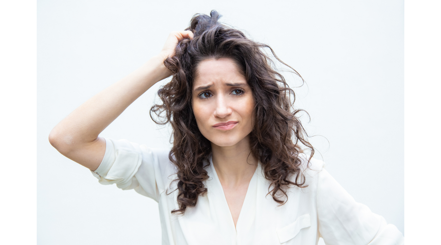 a young girl looking worried about her oily scalp