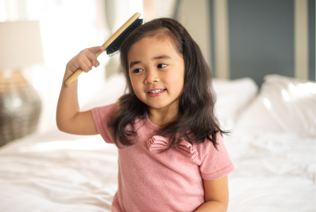 A little girl combing her hair